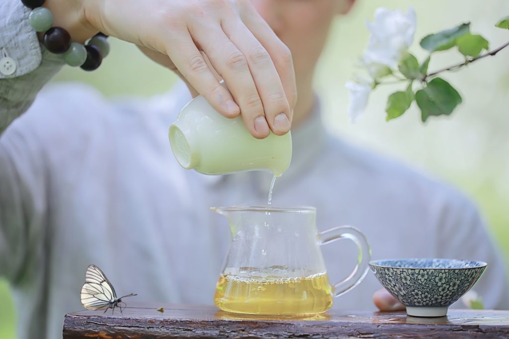 A person ready to enjoy Jasmine tea after the brewing process